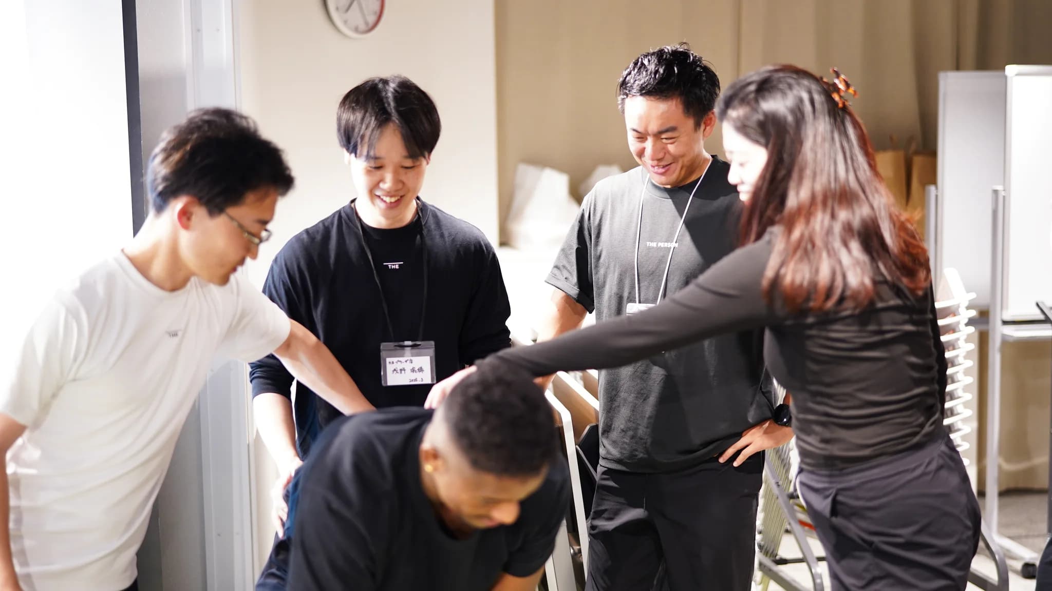 研修の様子。ひとりの動作を、まわりのトレーナーが手を添えながら一緒に確認している